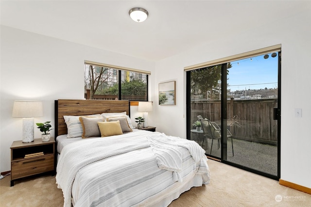 carpeted bedroom with multiple windows and access to outside