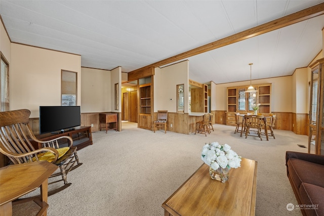 living room featuring crown molding, wooden walls, lofted ceiling with beams, and carpet