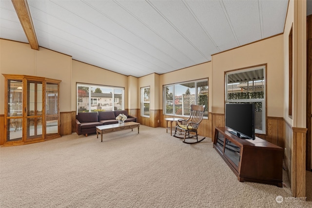 living room featuring wooden walls, carpet flooring, and vaulted ceiling with beams