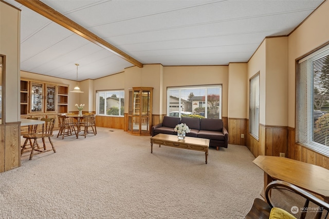 carpeted living room featuring vaulted ceiling with beams