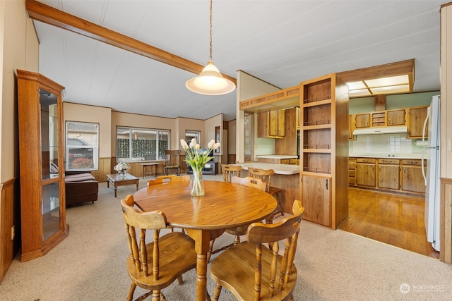 carpeted dining area with wooden walls