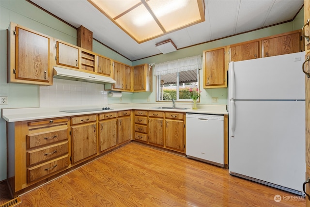 kitchen with light wood-type flooring, white appliances, sink, and backsplash