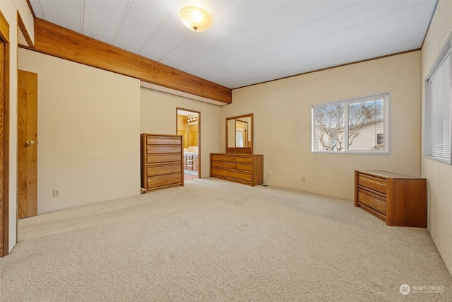 unfurnished bedroom with beam ceiling and light carpet