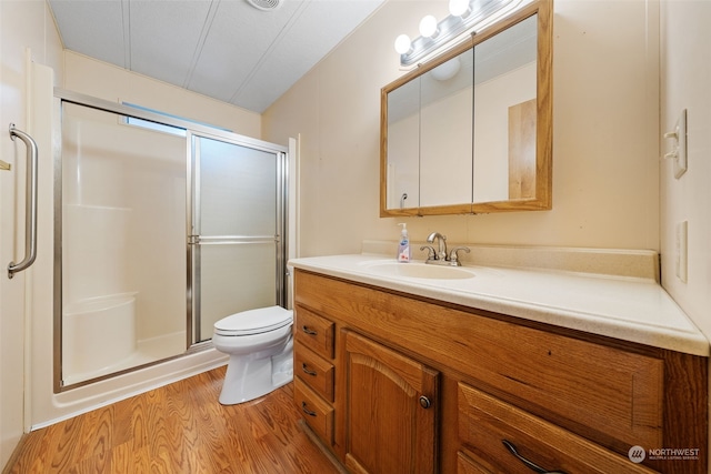 bathroom featuring vanity, an enclosed shower, hardwood / wood-style flooring, and toilet