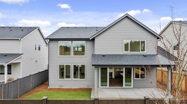 rear view of house with a patio, a yard, roof with shingles, and a fenced backyard