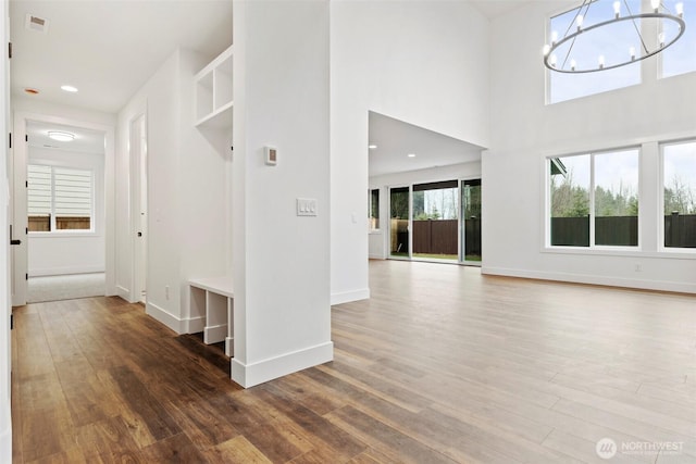 interior space featuring baseboards, wood finished floors, and an inviting chandelier