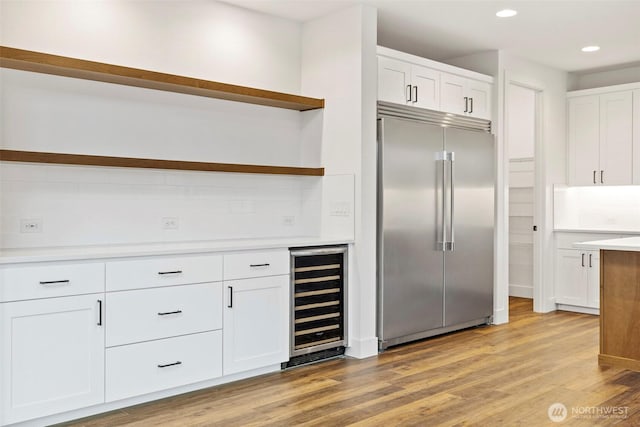 kitchen featuring open shelves, wine cooler, white cabinetry, and stainless steel built in fridge