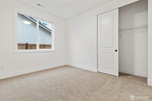 unfurnished bedroom featuring carpet, visible vents, baseboards, and a closet