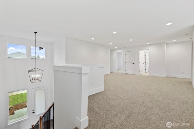 corridor featuring recessed lighting, light carpet, a notable chandelier, an upstairs landing, and baseboards