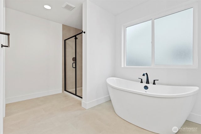 bathroom with recessed lighting, visible vents, a freestanding bath, a shower stall, and baseboards