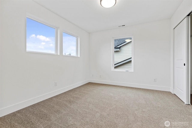 unfurnished bedroom with carpet floors, a closet, visible vents, and baseboards