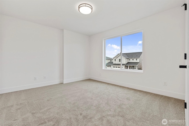 carpeted spare room with baseboards