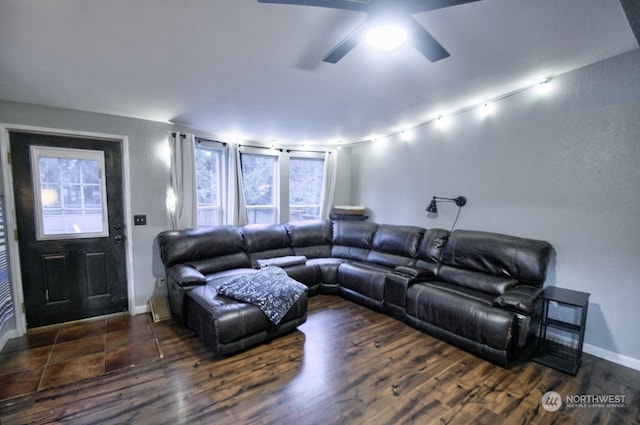 living room featuring ceiling fan and dark wood-type flooring