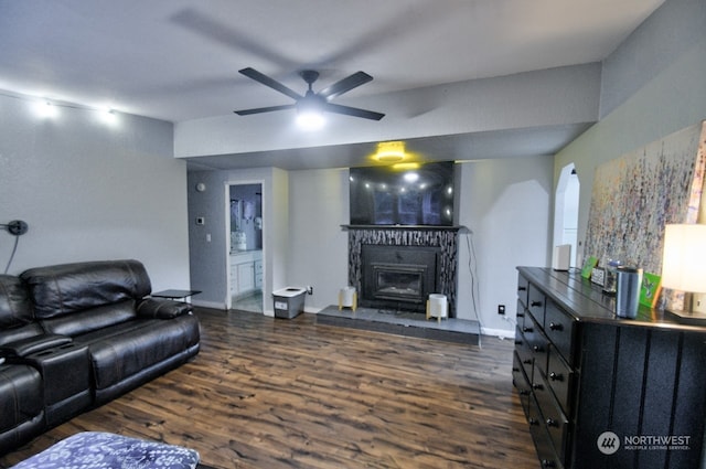 living room featuring ceiling fan and dark wood-type flooring