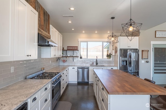 kitchen featuring white cabinets, appliances with stainless steel finishes, a kitchen island, and extractor fan