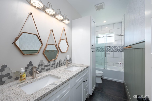 full bathroom with tiled shower / bath combo, toilet, and vanity