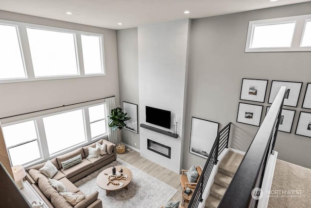 living room featuring a towering ceiling and hardwood / wood-style floors