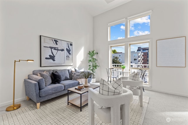 living room featuring light carpet and a high ceiling