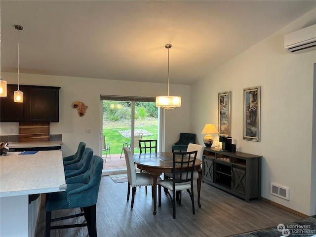 dining room with dark hardwood / wood-style flooring, lofted ceiling, and a wall mounted AC