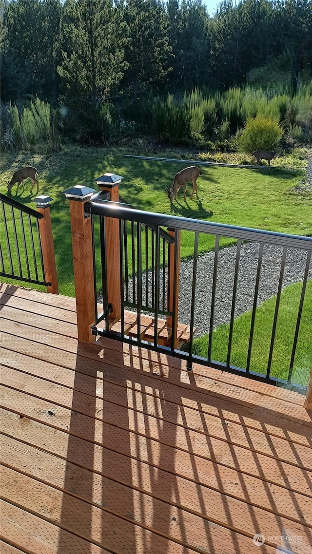 wooden terrace featuring a lawn