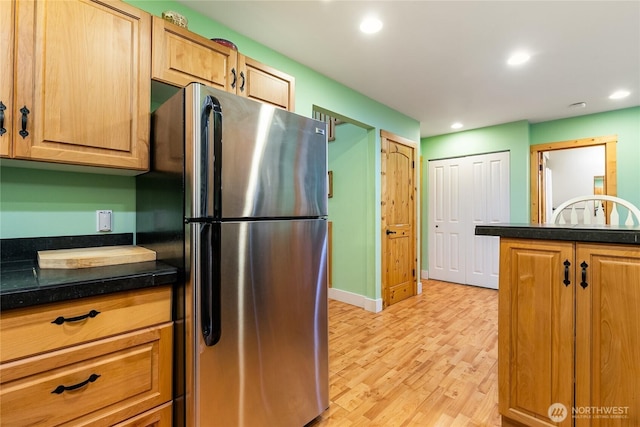 kitchen with recessed lighting, dark countertops, and freestanding refrigerator