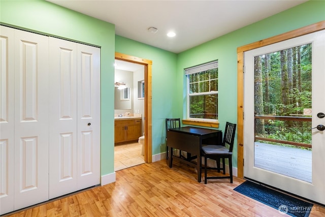 entryway featuring a sink, baseboards, and light wood-style floors