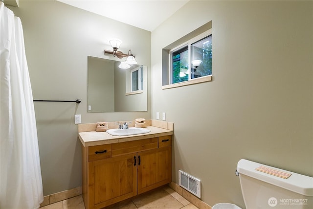 bathroom with vanity, visible vents, baseboards, tile patterned flooring, and toilet