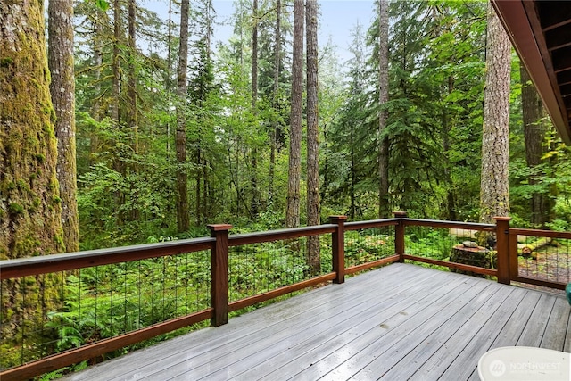 wooden terrace featuring a forest view