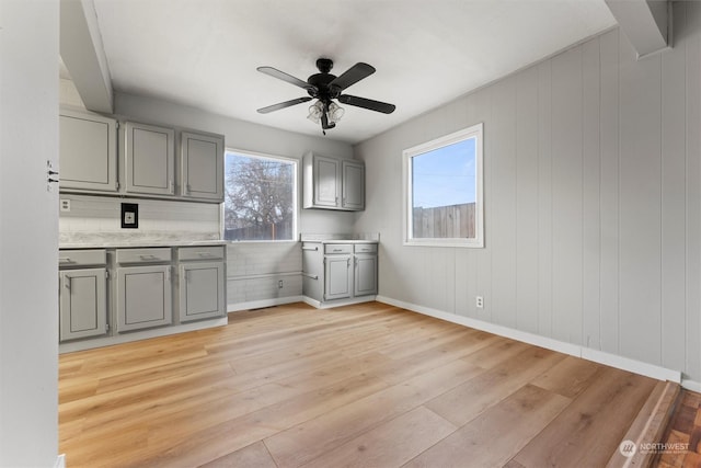 kitchen featuring gray cabinets, light hardwood / wood-style flooring, and ceiling fan