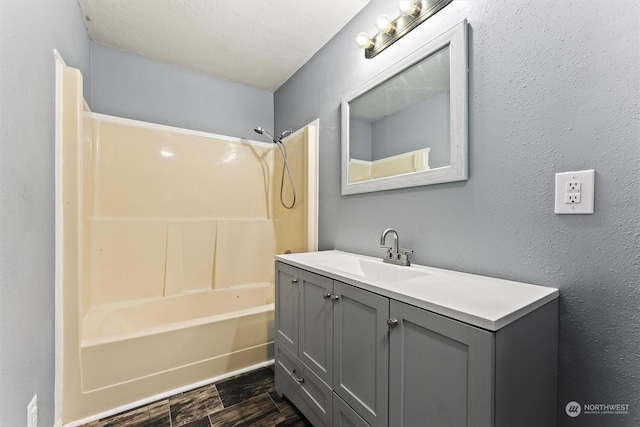 bathroom featuring shower / tub combination, vanity, and a textured ceiling