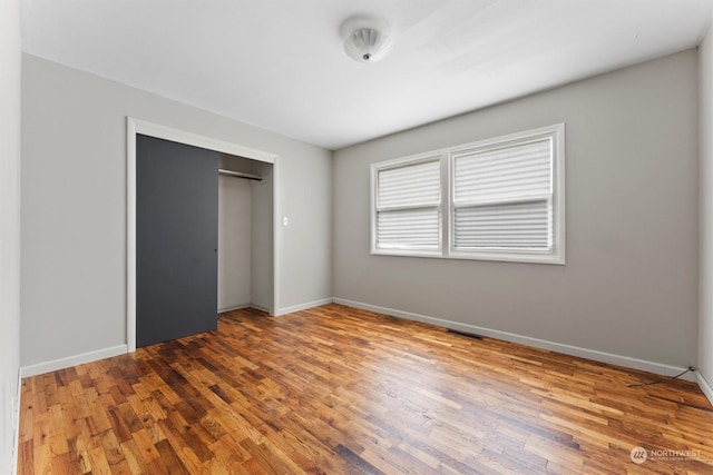 unfurnished bedroom featuring hardwood / wood-style flooring and a closet