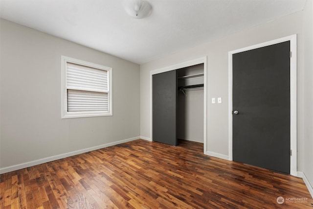 unfurnished bedroom with a closet and dark hardwood / wood-style floors