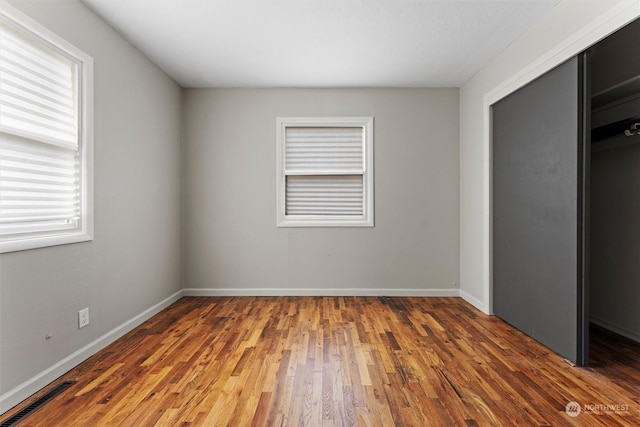 unfurnished bedroom featuring dark wood-type flooring and a closet