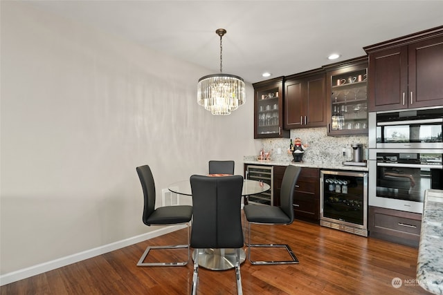 kitchen featuring light stone counters, a breakfast bar, dark brown cabinets, stainless steel double oven, and wine cooler