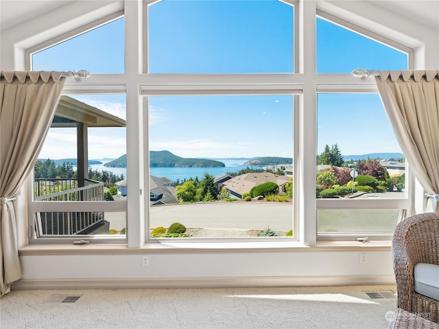 interior space featuring plenty of natural light, a water and mountain view, and vaulted ceiling