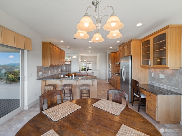 dining space featuring a chandelier, light tile patterned floors, and sink