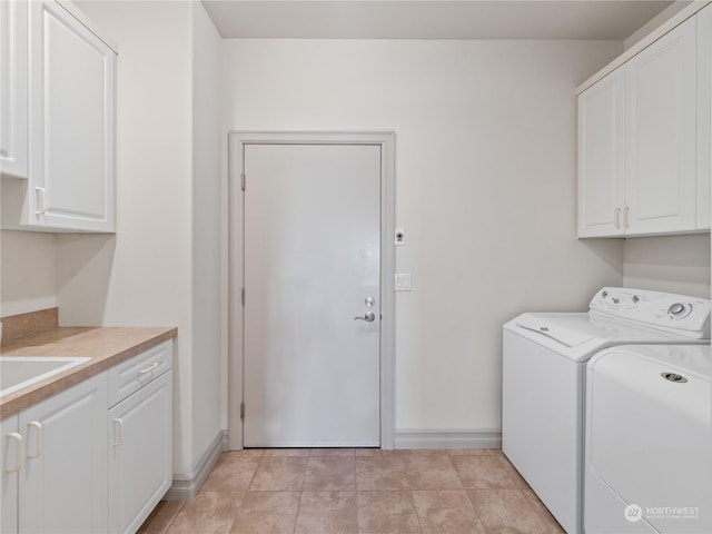 washroom featuring cabinets and washing machine and clothes dryer