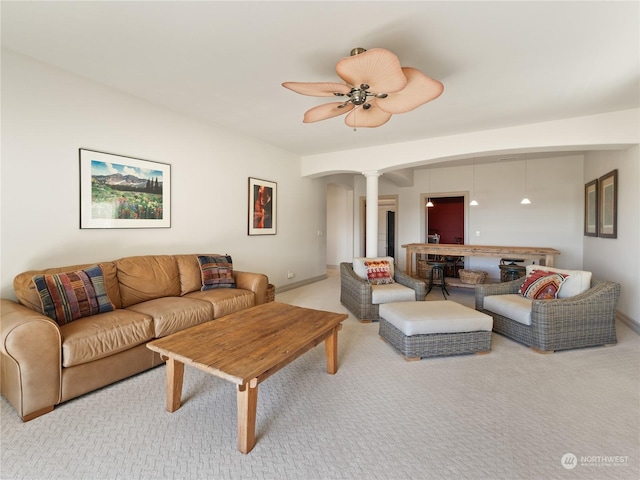 living room featuring ornate columns, ceiling fan, and carpet floors