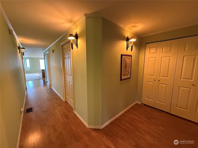 hall with light hardwood / wood-style floors and crown molding