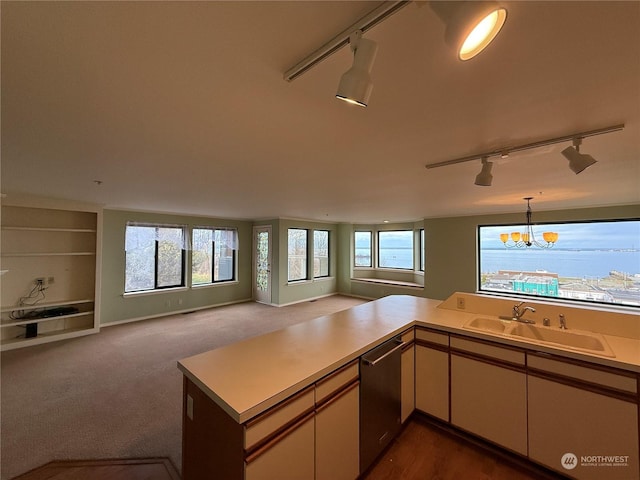 kitchen with dishwasher, sink, hanging light fixtures, a notable chandelier, and kitchen peninsula