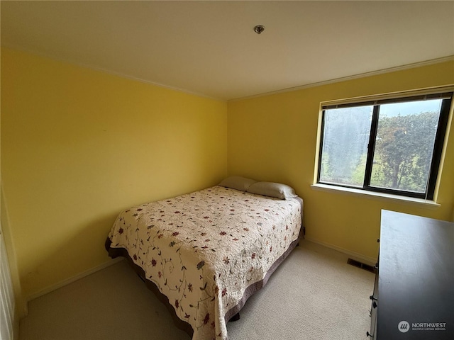 bedroom with light colored carpet and ornamental molding