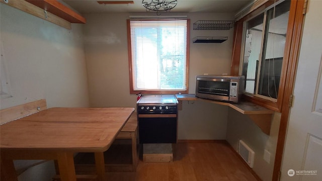 kitchen with black stove and light wood-type flooring