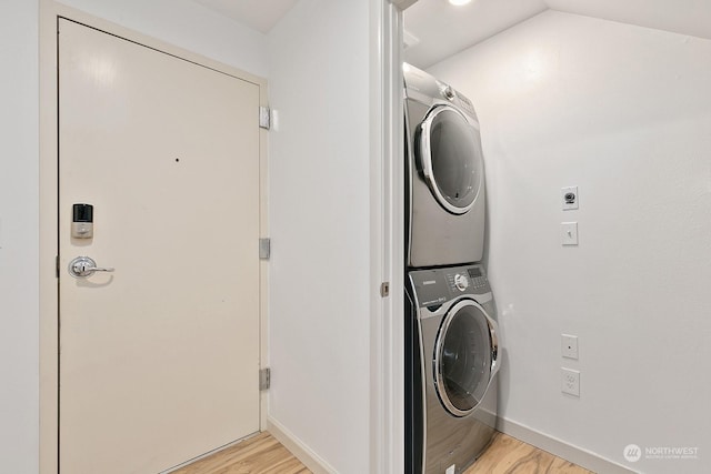 laundry room with light hardwood / wood-style floors and stacked washer and clothes dryer