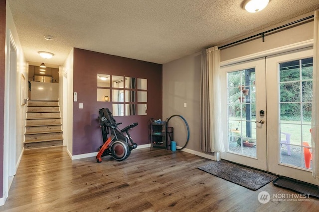 workout room with french doors, a healthy amount of sunlight, and wood-type flooring