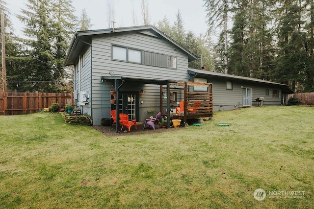 back of property featuring a lawn and a wooden deck