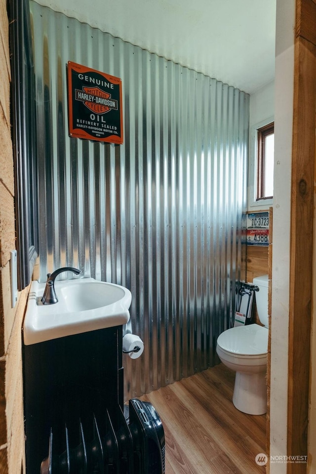 bathroom with hardwood / wood-style floors, vanity, and toilet