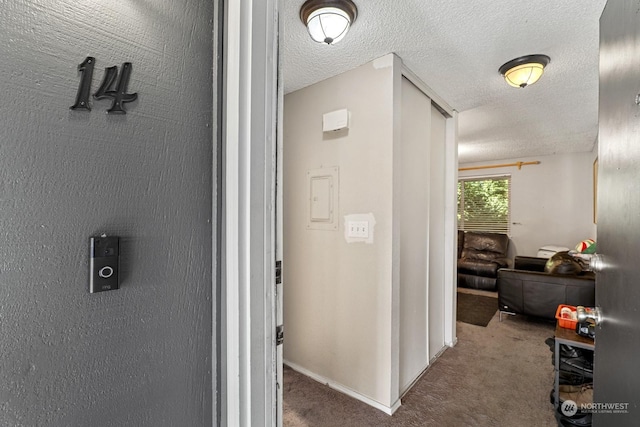 hallway featuring carpet floors and a textured ceiling