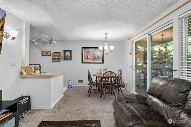 dining room featuring a textured ceiling, a chandelier, and carpet