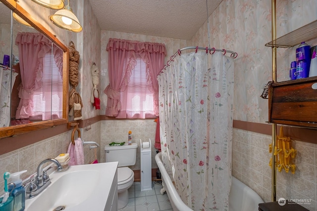 full bathroom featuring tile patterned floors, tile walls, a textured ceiling, toilet, and shower / tub combo