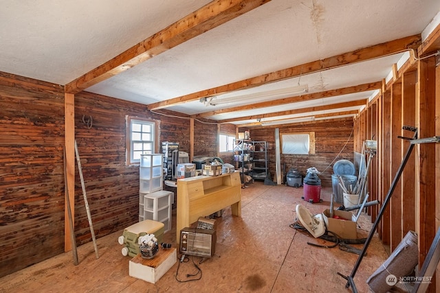 misc room featuring beam ceiling and wooden walls